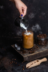 Cold coffee in a glass on a dark background