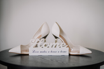 Large wooden lettering 'Home' stands on white shelves with shoes