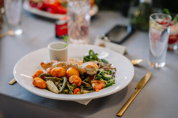 Delicious grilled or roasted salmon, corn, potatoes and salad are served in an elegant restaurant or hotel.