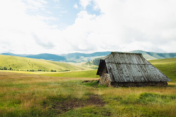 Fototapeta na wymiar Amazing green pastures and small farmer hut in the hills of resort Zlatibor Serbia