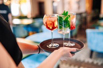 glasses alcohol cocktail set on a waiter tray in bar