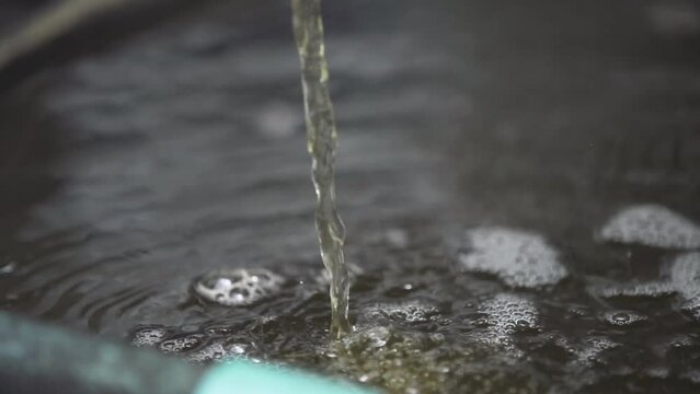 Pure biodiesel fluid flows from the hose into the reservoir.