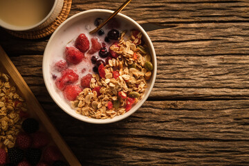 A cup of milk with bowl of oat granola with fresh milk and berries for healthy breakfast. Vegeterian, dieting and weight loss concept.