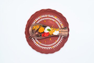 TOP VIEW DECORATIVE THALI WITH KOSHA KHUSI,FLOERS PETALS ISOALTED ON WHITE BACKGROUND.