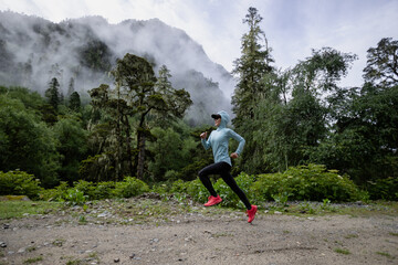 Fototapeta premium Woman trail runner cross country running in high altitude mountain forest