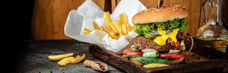A big burger with a juicy cutlet, cheese sauce and salad, Long banner format