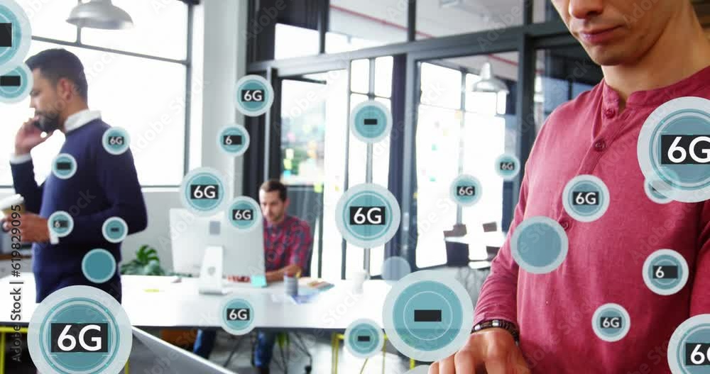Poster animation of symbols and 6g text in circles over caucasian man standing and using laptop in office