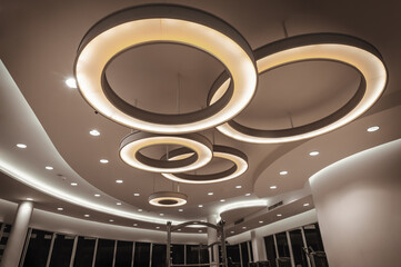 Hanging rounded ceiling mounted light fixtures with modern LED light bulb. Yellow circular ring...