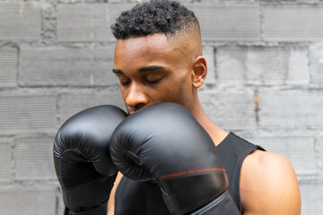 Black sportsman fighting in modern gym