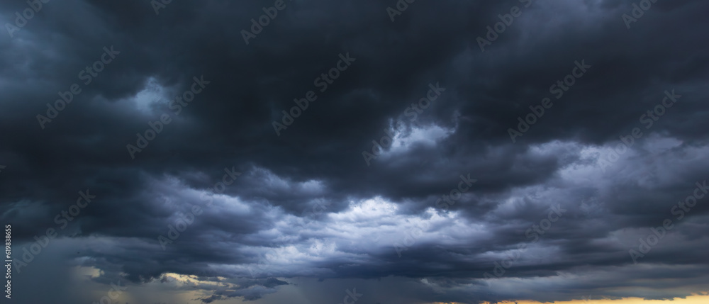 Wall mural The dark sky with heavy clouds converging and a violent storm before the rain.Bad or moody weather sky and environment. carbon dioxide emissions, greenhouse effect, global warming, climate change.