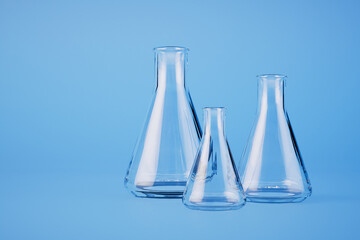 glass flasks for liquids or chemicals on a blue background. 3D render