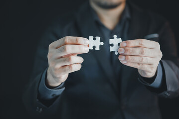 Business woman person hand holding puzzle piece idea for strategy and solution. Closeup part of two...
