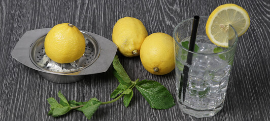 Spremuta di limone nel bicchiere con ghiaccio e foglie di menta 