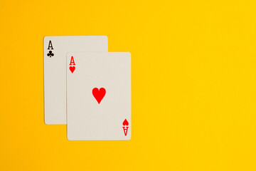 Two Ace playing cards on yellow background with copy space