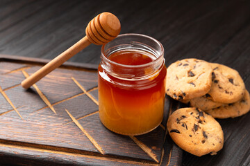 Honey and homemade cookies on a wooden background