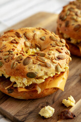 Homemade Bacon, Egg & Cheese Bagel Breakfast Sandwich on a wooden board, side view. Close-up.