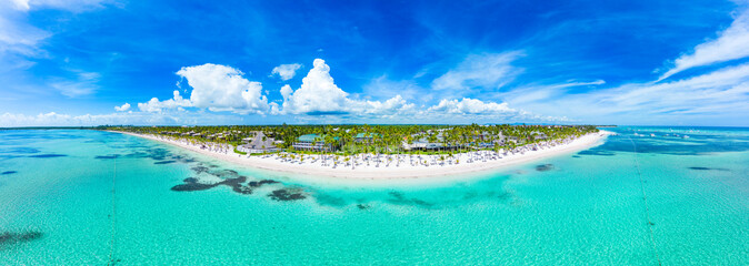 Fototapeta na wymiar Aerial panorama of the tropical island and beach with white sand and turquoise water of the Caribbean Sea. Top places for summer vacations in all Inclusive resorts and hotels in Punta Cana