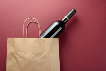 Paper shopping bag with a bottle of red wine.