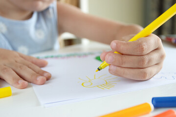 Cute child drawing a picture with colored felt-tip pens. Concept of education