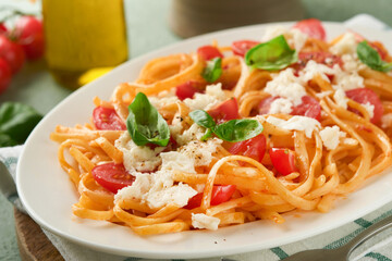 Salad caprese or pasta spaghetti broken with basil and mozzarella ala caprese on white plate on...