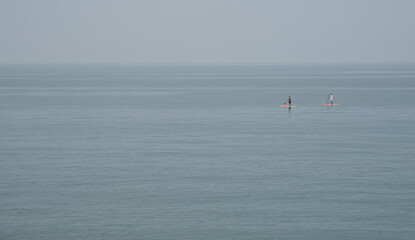 Fototapeta na wymiar Unrecognized people canoeing in the sea in the morning. People exercising in the ocean.