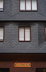 fachada de teja gris con rótulo luminoso en la parte de abajo escrito en idioma alemán