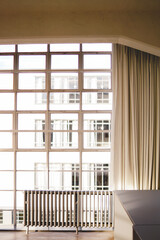 vista frontal de un ventanal de acero con cortinas y un radiador