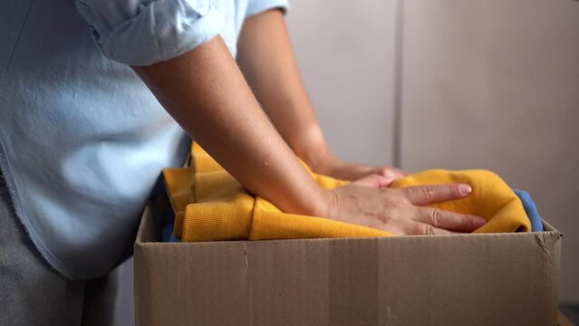 Woman donates her clothes. Sale of used clothes. Donation	