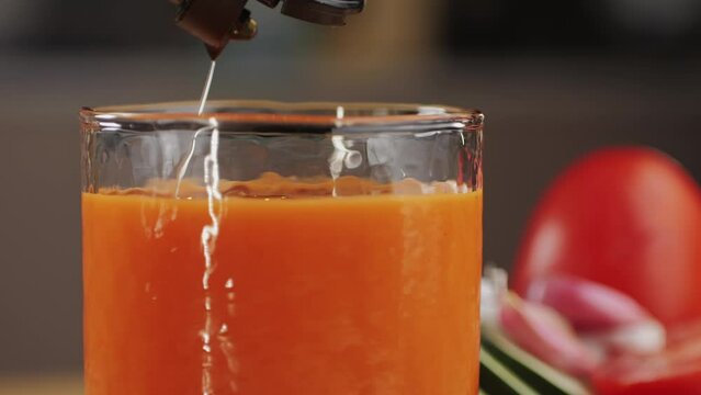 Tomato gazpacho Spanish cold soup with pepper and garlic, Spanish traditional cuisine, chef cooking dinner with carrot juice.