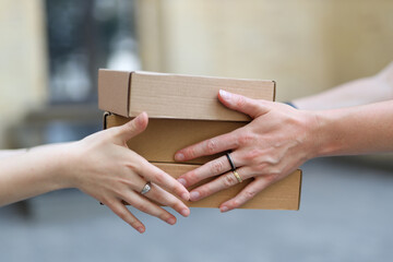 Passing cardboard boxes from hand to hand close-up.