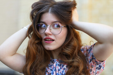 Fashionable young woman straightens her hair.