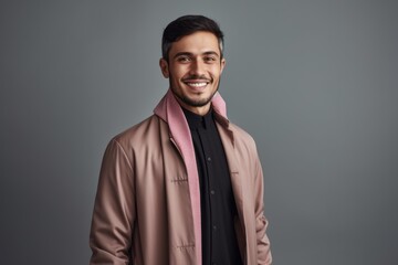 Obraz premium smiling young man in beige coat looking at camera isolated on grey