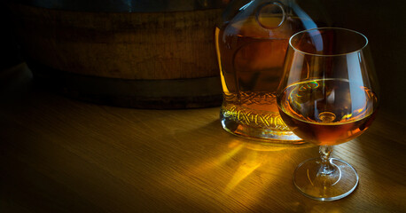 a brandy glass; bottle and barrel; luxurious men's club banner background with copy space