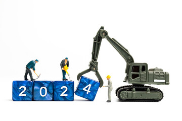 Miniature people , Worker team flips a block with the number 2024, On a white background