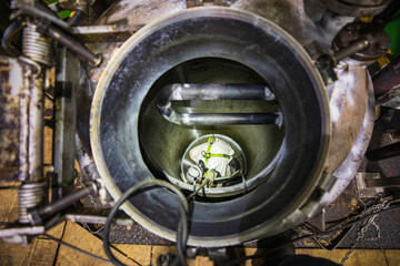 Top view male worker climbs up the stairs into the tank carbon chemical grease area confined