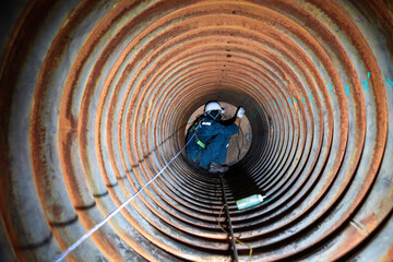 Male worker inspection measured the coil pipe circular thickness of the boiler scan minimum thickness into line rope access symbol dangerous confined