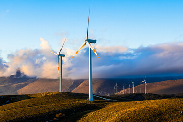 a wind farm full of turbines in the Italian mountains. The green economy and technology are the...