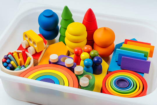 Colorful wooden toys in the colors of the rainbow in plastic box.  Concept of organizing and storing children's toys. Games for learning and development of the child.