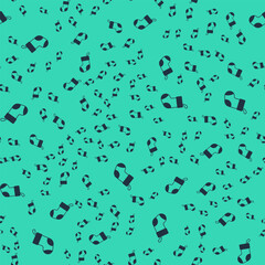 Black Christmas stocking icon isolated seamless pattern on green background. Merry Christmas and Happy New Year. Vector