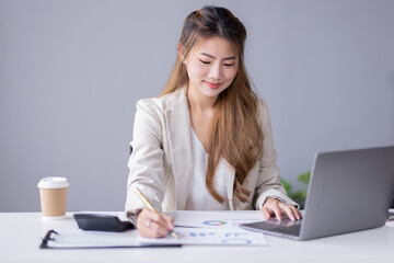 Financial Business asian women analyze the graph of the company's performance to create profits and growth, Market research reports and income statistics, Financial and Accounting concept.	