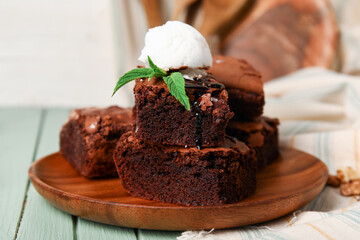 Plate with pieces of tasty chocolate brownie and ice cream on table