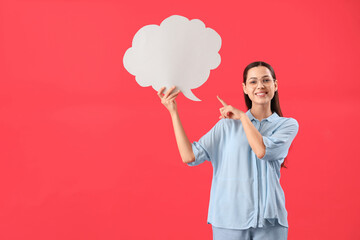 Young woman pointing at blank speech bubble on red background
