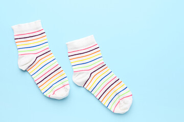 Pair of striped socks on color background