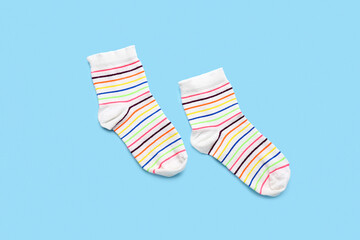 Pair of striped socks on color background