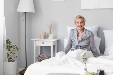 Mature woman waking up in bedroom