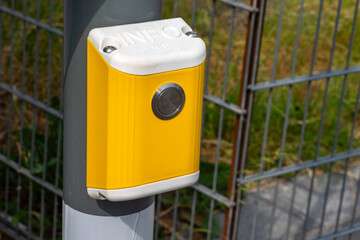 Bright yellow-white button to call information at the bus stop. Close up.