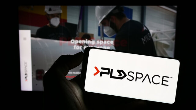 Stuttgart, Germany - 06-23-2023: Person holding cellphone with logo of company Payload Aerospace S.L. (PLD Space) on screen in front of business webpage. Focus on phone display.