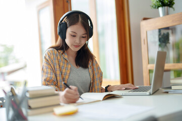 Self learning concept. Young woman student wear headphone listening audiobook technology education