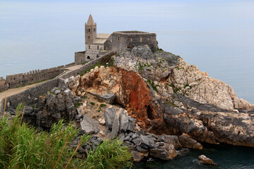 Landscape view of the Chiesa di San Pietro church on a stone hill and the Ligurian Sea in the...
