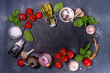 Obraz na płótnie Canvas Black cooking background with useful cooking italian Mediterranean ingredients - tomatoes, basil leaves, greens, olive oil, salt, pepper, garlic, flat lay black concrete table top view copy space